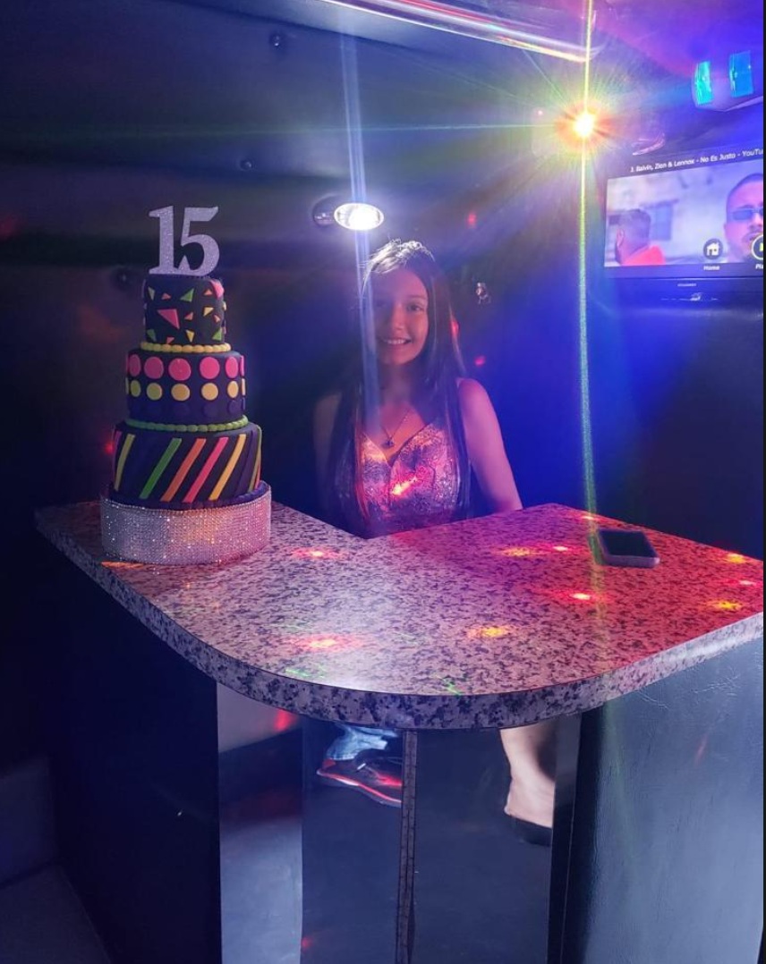 Quinceañera celebrando con su bizcocho dentro del party bus